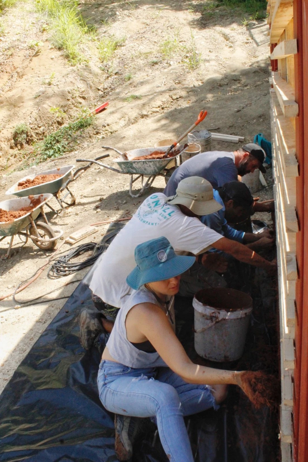 Person smiling while filling a bahareque wall