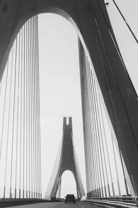 Cable-stayed bridge seen from the road, black and white
