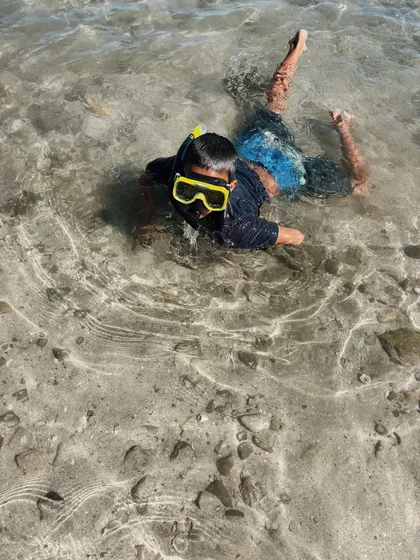 Child with a mask exploring a tide pool